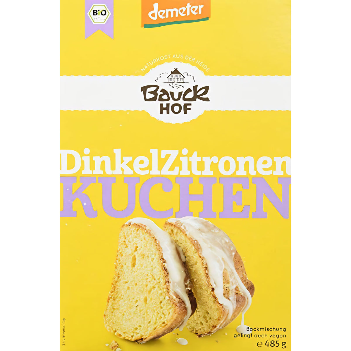 Bauck Demeter Dinkel Zitronenkuchen, gebacken, in Scheiben geschnitten, auf einem Teller, mit Zitronenscheiben und Puderzucker garniert