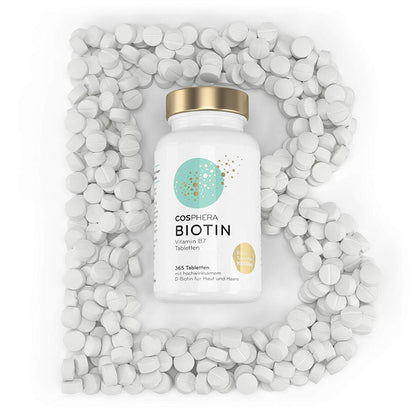dose cosphera biotin tabletten von oben, umgeben von vielen weißen tabletten in B-Form angeordnet