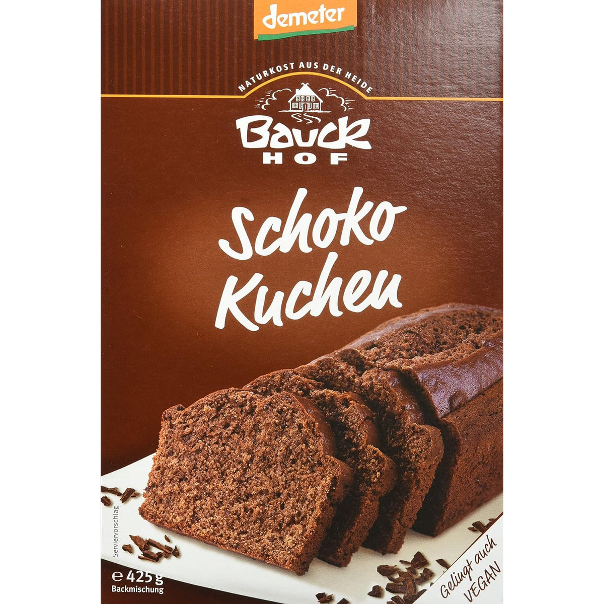 Nahaufnahme der bauckhof schokokuchen backmischung 6x425g, Vorderseite mit angeschnittenem Schokokuchen und Schokoraspeln.