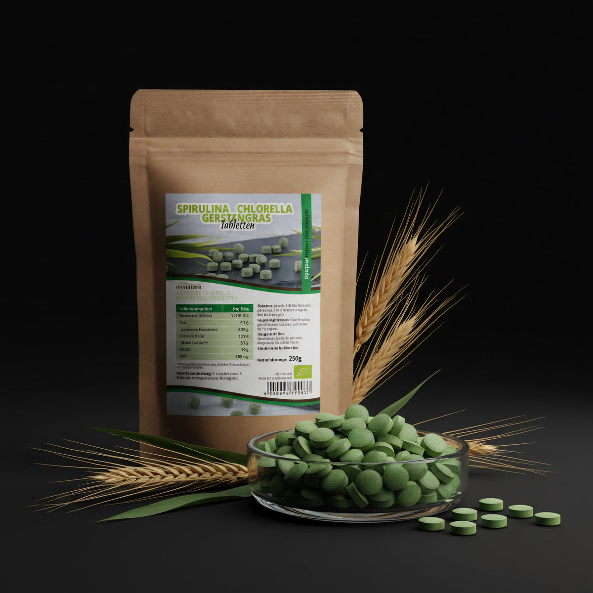 An artistic, studio-style product shot emphasizing the purity and eco-conscious origin of the 'Mynatura' tablets. The tablets are displayed in an elegant, transparent dish, set within a minimalist environment decorated with natural elements like wheat stal