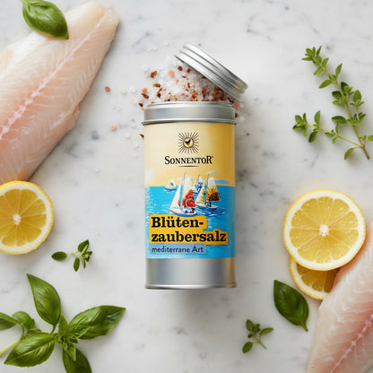 Create a cinematic overhead shot of the 'Blütenzaubersalz' on a pristine white marble countertop, styled next to fresh ingredients like fillets of fish, lemon slices, and sprigs of basil and oregano. Employ professional HDR studio lighting with soft shadow