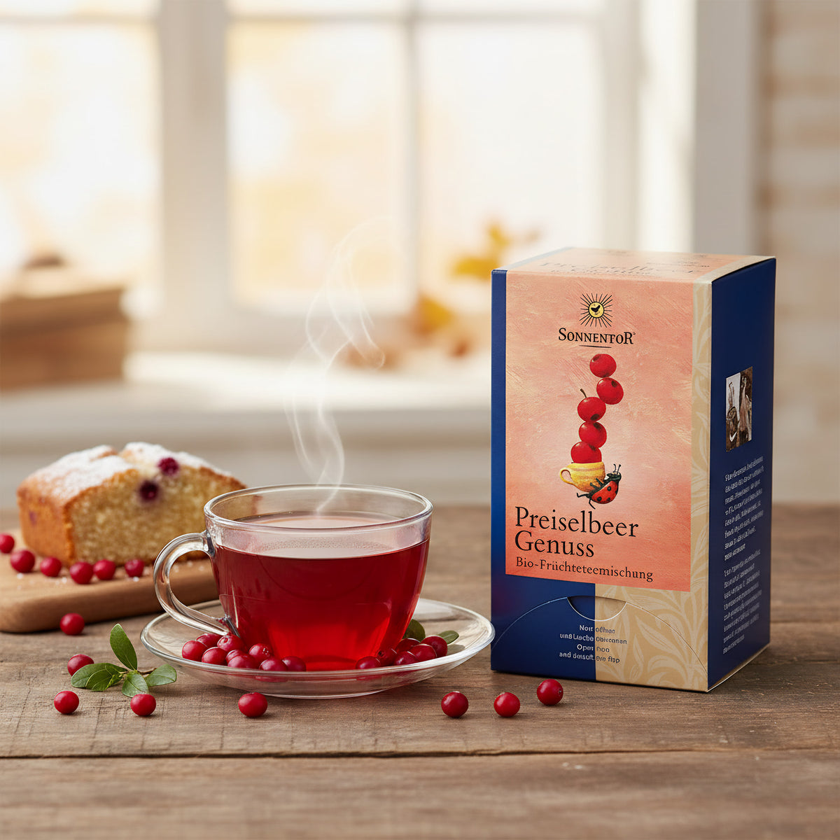 An elegant lifestyle scene featuring a steaming cup of the Preiselbeer Früchtetee placed on a rustic wooden table, surrounded by fresh wild berries and a slice of cake to suggest pairing. Natural daylight with a slight diffuser creates a warm, inviting atm