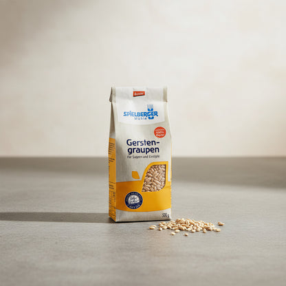 Small 500g organic barley packet on stone countertop with spilled grains, showcasing eco-friendly packaging and wholesome appeal.
