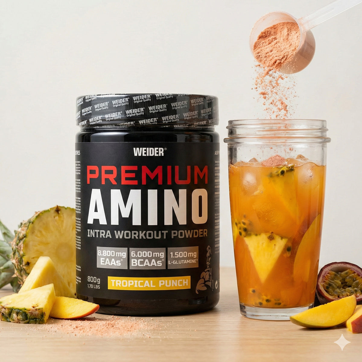 Weider Premium Amino Pulver 800g neben einem Glas mit gemischtem Getränk, frischen Fruchtstücken und einem Dosierlöffel mit Pulver.