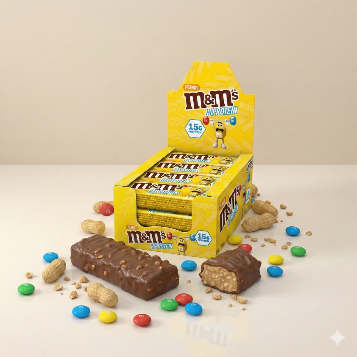 M&M's Protein Bar Eiweißriegel 12x51g in offener Box, davor ein ganzer und ein halbierter Riegel, umgeben von M&M's, Erdnüssen und Krümeln.
