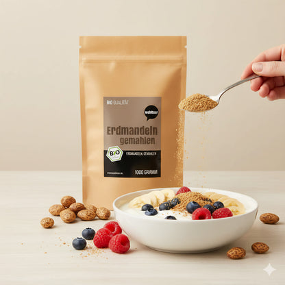 wohltuer Erdmandelmehl-Beutel neben einer Schale Müsli mit frischen Beeren, Bananen und einem Löffel Erdmandelmehl, ideal zum Backen und Kochen.
