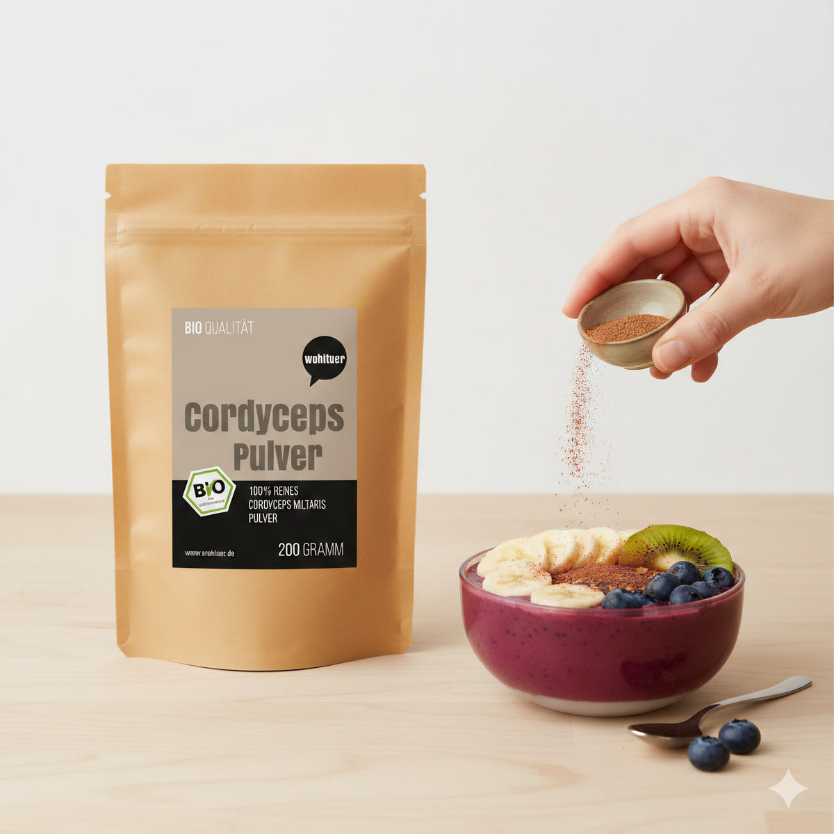 wohltuer cordyceps pulver 200g neben einer smoothie-bowl zum frühstück, hand streut pulver aus einer schale darüber.