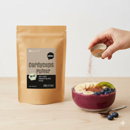 wohltuer cordyceps pulver 200g neben einer smoothie-bowl zum frühstück, hand streut pulver aus einer schale darüber.