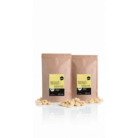 Zwei braune Beutel wohltuer Maulbeeren getrocknet 500g, umgeben von getrockneten Früchten auf weißem Untergrund.