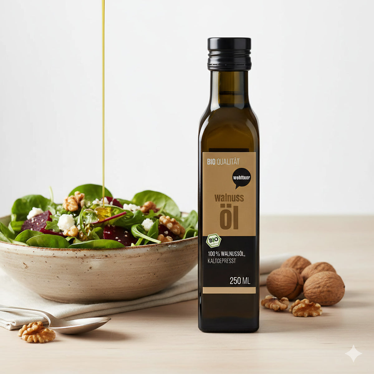 wohltuer Walnussöl 250ml neben einer Schüssel Salat mit Walnüssen, Öl wird über den Salat gegossen, im Vordergrund ein Löffel mit Walnuss.
