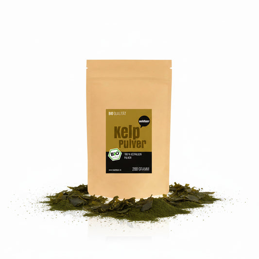 Wohltuer Kelp Pulver 200g im braunen Standbeutel, umgeben von grünem Algenpulver und getrockneten Algenblättern auf weißem Hintergrund.