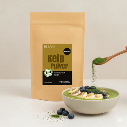 Wohltuer Kelp Algenpulver 200g neben einer Smoothie-Bowl, auf die mit einem Holzlöffel grünes Pulver als Topping gestreut wird.