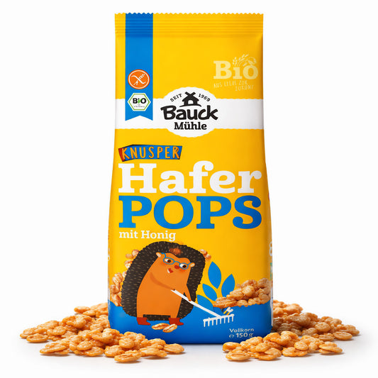 Packung Bauckhof Haferpops mit Honig, stehend auf weißem Hintergrund, umgeben von verstreuten glutenfreien Pops als Frühstücks-Snack.