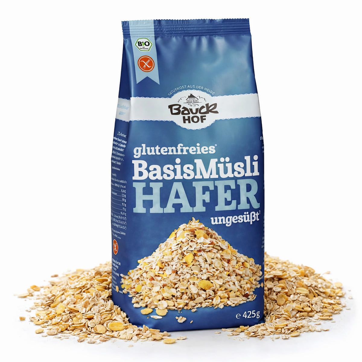 Packung Bauckhof Hafermüsli Basis glutenfrei stehend, umgeben von losem Müsli auf weißem Hintergrund.