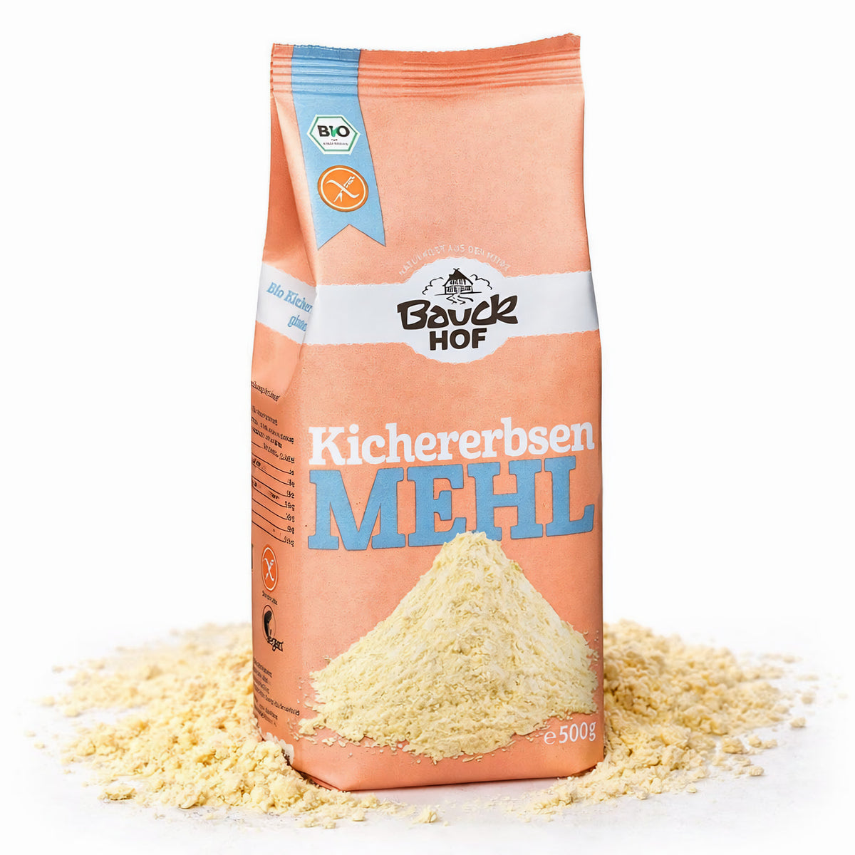 Bauckhof Kichererbsenmehl in orangefarbener Verpackung, stehend auf verstreutem Mehl, Vorderseite mit Produktname, Bio- und Glutenfrei-Siegel.