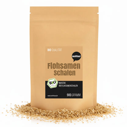 Beutel wohltuer indische Flohsamenschalen 900g, stehend auf verstreuten Flohsamen, Vorderseite mit Etikett sichtbar.