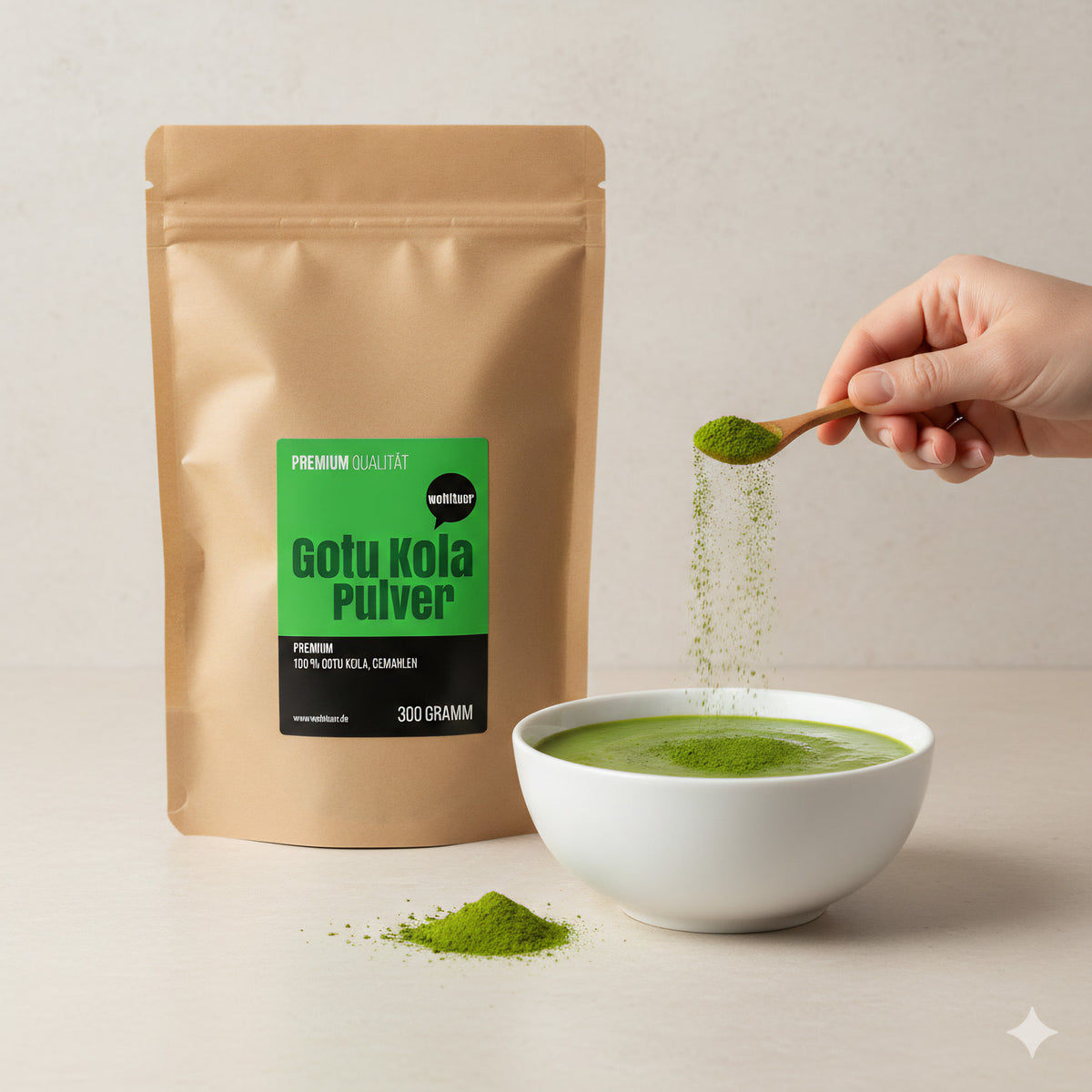 wohltuer Gotu Kola Pulver 300g neben einer weißen Schale mit grünem Getränk, eine Hand streut Pulver mit einem Löffel hinein.
