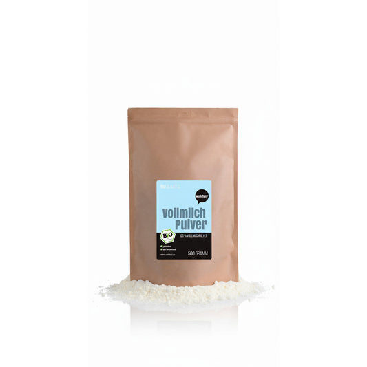 Beutel wohltuer Vollmilchpulver 500g stehend, davor etwas lösliches Pulver auf weißem Untergrund.