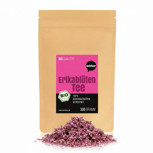 Beutel wohltuer Bio ErikablütenTee gerebelt 300g mit losem Haufen getrockneter Erikablüten davor auf weißem Hintergrund.