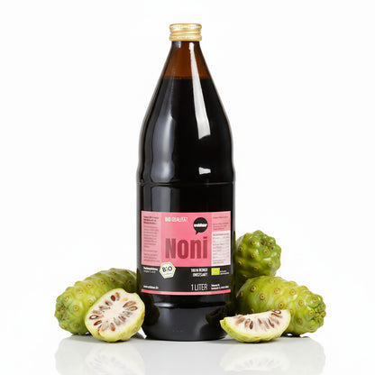 Wohltuer Noni Saft in brauner 1-Liter-Flasche, umgeben von ganzen und aufgeschnittenen Noni-Früchten auf weißem Hintergrund.