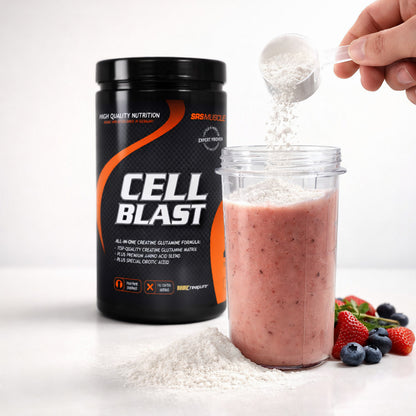 Cell Blast Creatine Glutamine Pulver wird mit einem Messlöffel in einen Becher mit rosa Getränk gegeben, daneben frische Beeren und Pulverhäufchen.