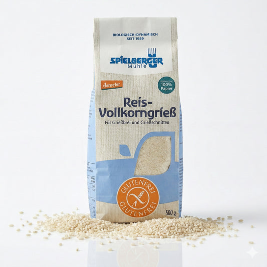 Packung spielberger glutenfreier Reis-Vollkorngrieß auf weißem Hintergrund, umgeben von verstreutem Reis, Vorderseite mit Produktinformationen sichtbar.