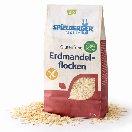 Packung spielberger glutenfreie erdmandelflocken 250g stehend, Flocken sind vor der Verpackung verstreut sichtbar.