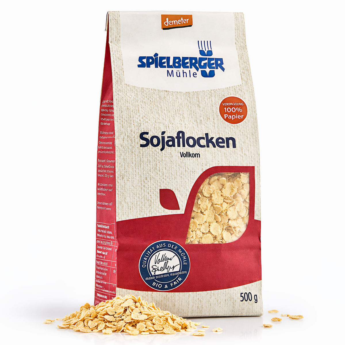Packung spielberger sojaflocken demeter 500g stehend, vorne sichtbar, daneben lose Flocken auf weißem Untergrund.