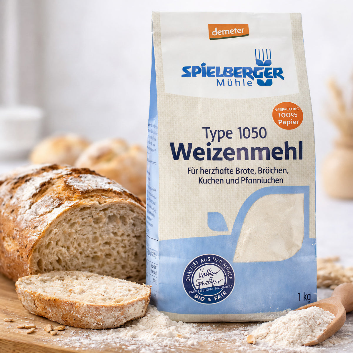 Eine Packung spielberger Weizenmehl 1050 steht auf einem Holzbrett neben angeschnittenem Brot und etwas verstreutem Mehl.