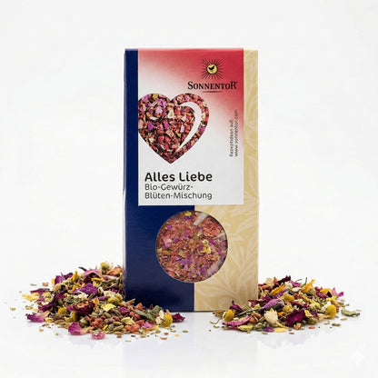 Sonnentor Alles Liebe Gewürz-Blüten-Mischung im 40g Pack, stehend vor weißem Hintergrund, umgeben von verstreuten Blüten und Gewürzen als Topping.