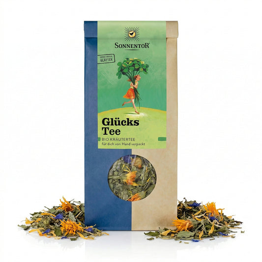 Packung Sonnentor Glückstee lose 2x50g mit Sichtfenster, umgeben von getrockneten Kräutern und Blüten auf weißem Hintergrund.