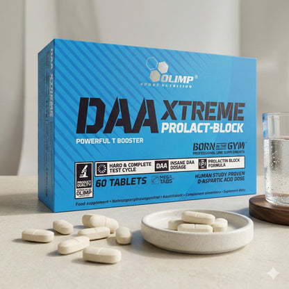 Olimp DAA Xtreme Tabletten auf einem kleinen Teller neben einem Glas Wasser, weitere Tabletten liegen auf dem Tisch vor der Packung.