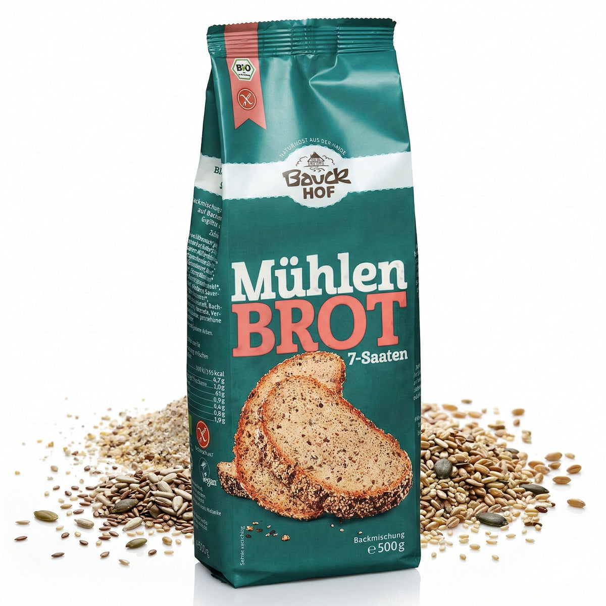 Packung Bauckhof Mühlenbrot 7-Saaten Backmischung, stehend vor verstreuten Saaten auf weißem Hintergrund.