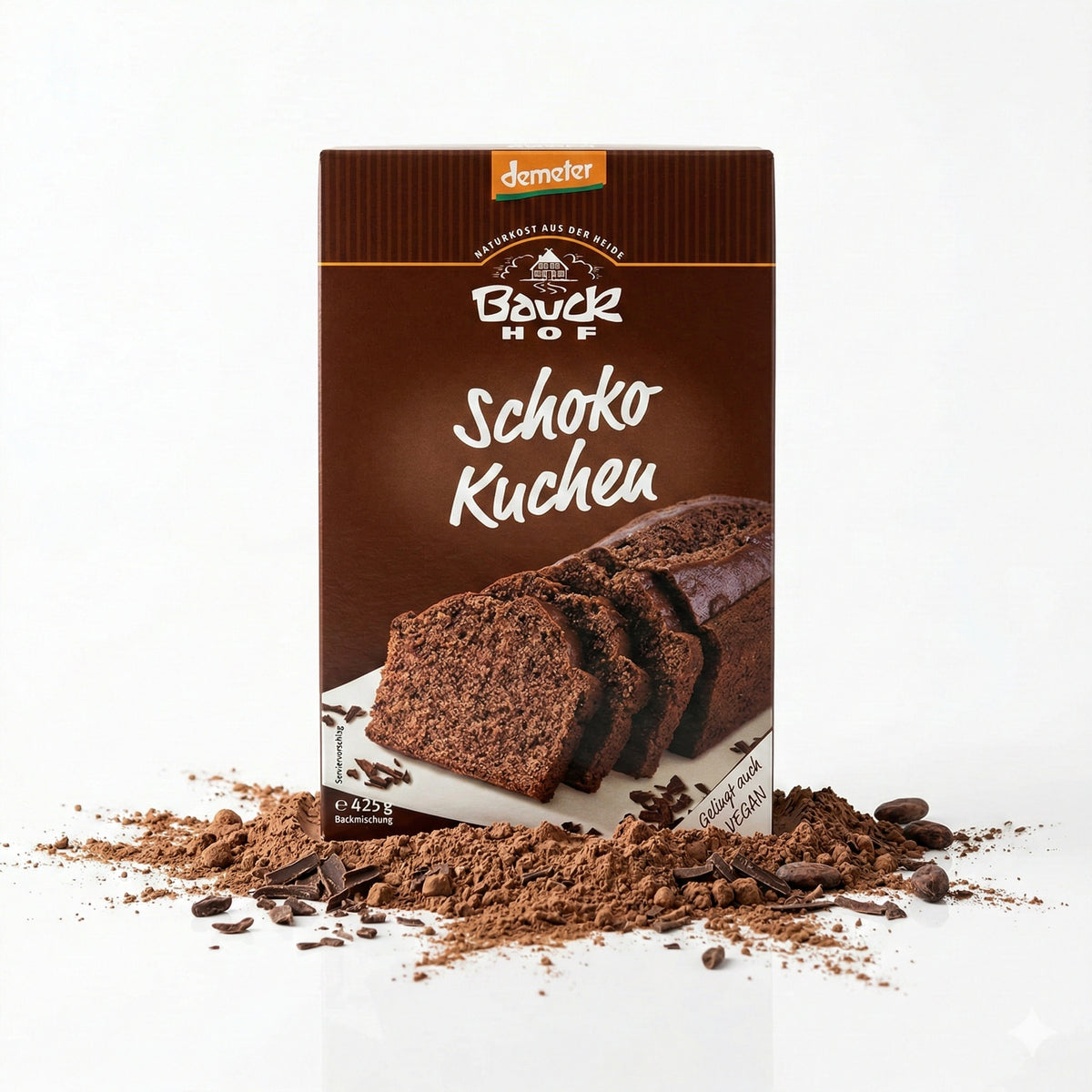 bauckhof schokokuchen backmischung aufrecht stehend, umgeben von Kakaopulver und Schokostückchen, frontal fotografiert.
