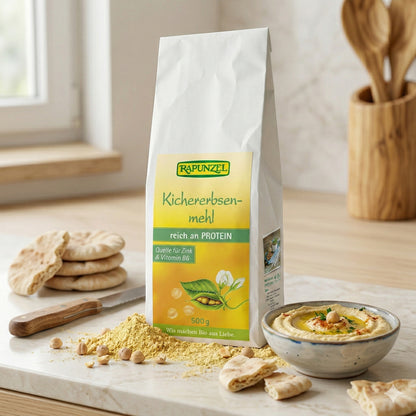 Geröstetes Bio-Kichererbsenmehl von Rapunzel in 500g-Packung, ideal zum Kochen und Backen, in einer transparenten Schüssel.
