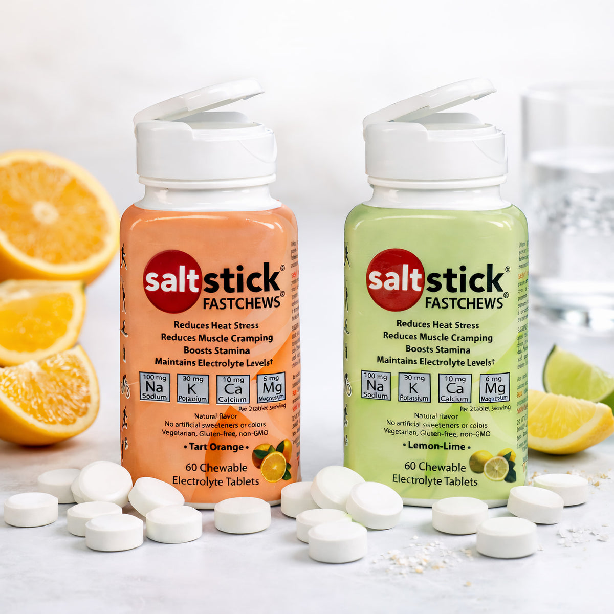 SaltStick Fast Chews Elektrolyt-Kautabletten in Orange- und Zitronen-Limetten-Geschmack, umgeben von Zitronen- und Limettenstücken sowie weißen Kautabletten auf hellem Untergrund.