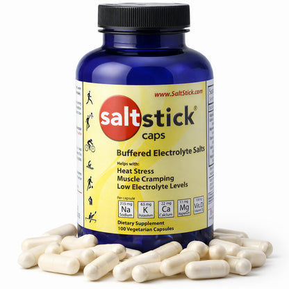 SaltStick Mineralstoffkapseln in blauer Dose mit gelbem Etikett, umgeben von weißen Kapseln auf weißem Hintergrund.