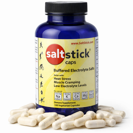 SaltStick Mineralstoffkapseln in blauer Dose mit gelbem Etikett, umgeben von weißen Kapseln auf weißem Hintergrund.