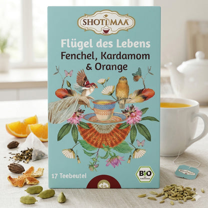 Bio Kräutertee von Shoti Maa, "Flügel des Lebens", mit Teebeuteln in 2x32g, zeigt dampfenden Tee in einer Tasse vor grünen Kräutern