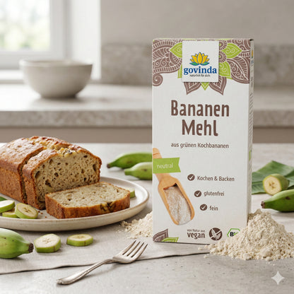 Govinda Bananenmehl aus grünen Kochbananen, 350g, neben Mehlhaufen, Bananenbrot und geschnittenen grünen Kochbananen auf einem Teller