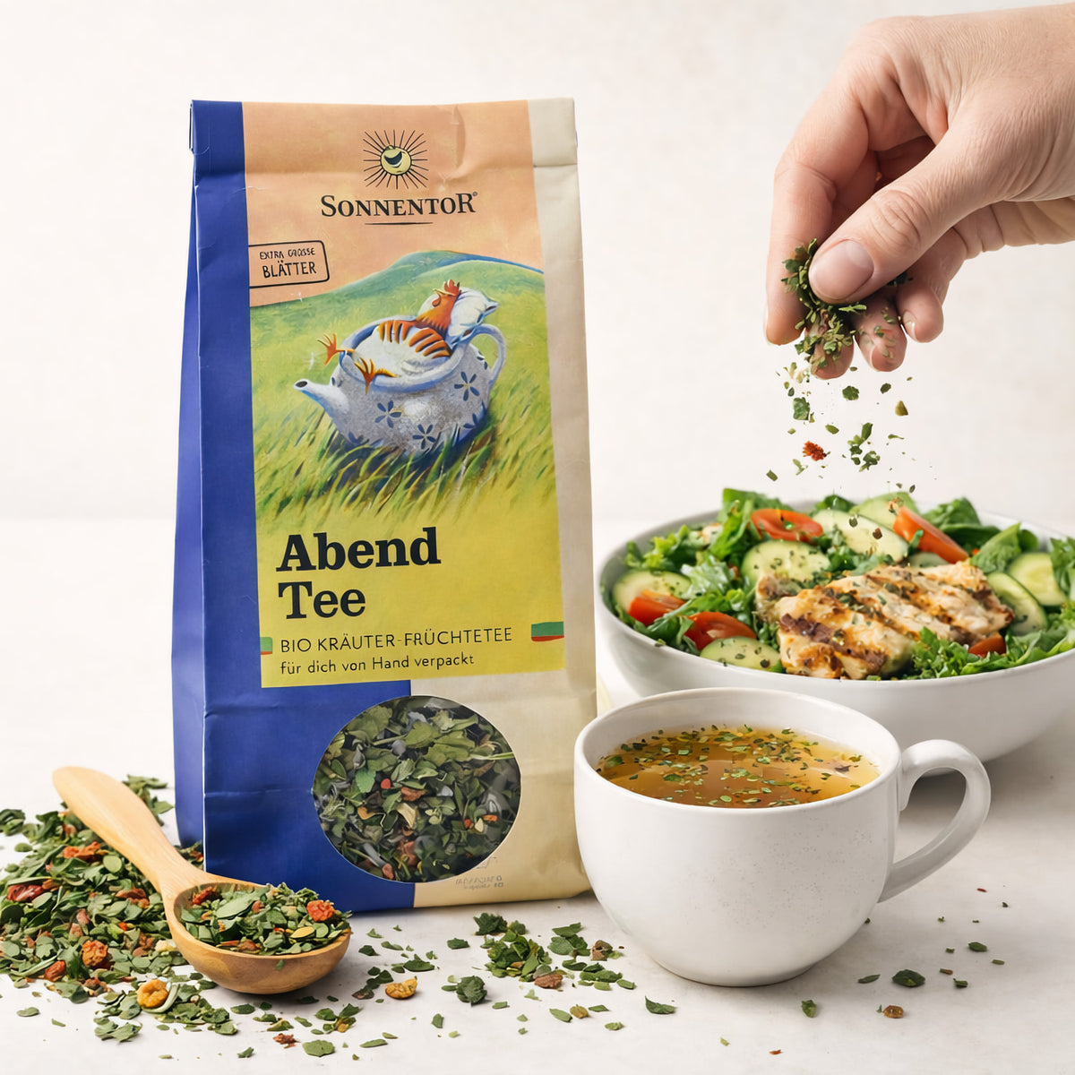 Tasse mit Sonnentor Abendtee lose ab 50g, aromatischer Kräutertee in einer offenen Packung, Nahaufnahme des Tees und der Verpackung