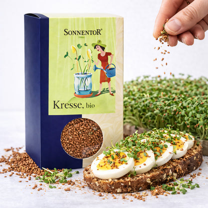 Bio Kresse von Sonnentor, frisch auf einem Frühstücksteller, zeigt grüne, zarte Kresseblätter in einem natürlichen Bild.