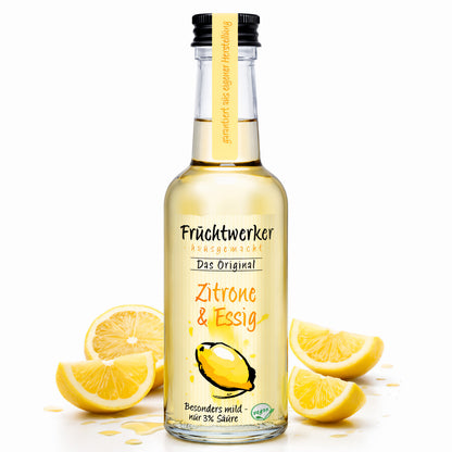 Fruchtwerker Zitronen- und Essigöl in 250ml Flasche, Glasbehälter mit gelber Zitrone und Essig im Hintergrund