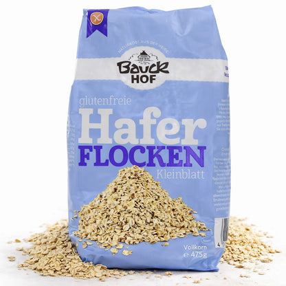 Packung Bauckhof Haferflocken Kleinblatt mit losem Hafer auf weißem Untergrund, Vorderseite gut lesbar.