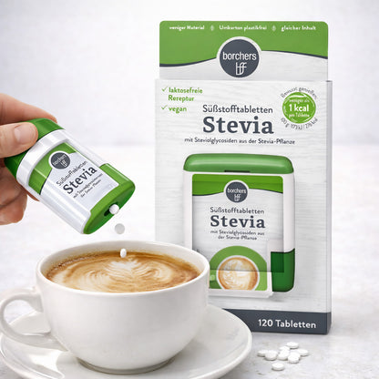 hand hält borchers stevia spender und gibt süßstofftabletten in eine tasse cappuccino, packung und weitere tabletten im hintergrund