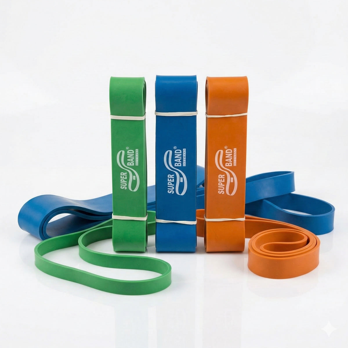Dittmann SUPERBAND 3er Set in Rot, Grün und Orange, Gymnastikbänder für Reha und Therapie, auf weißem Hintergrund.