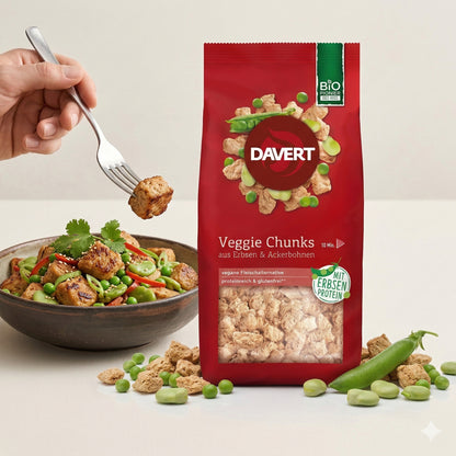 Davert Veggie Chunks 100g neben einer Schale mit gebratenen Chunks und Gemüse, eine Hand hält eine Gabel mit einem Stück Chunks.