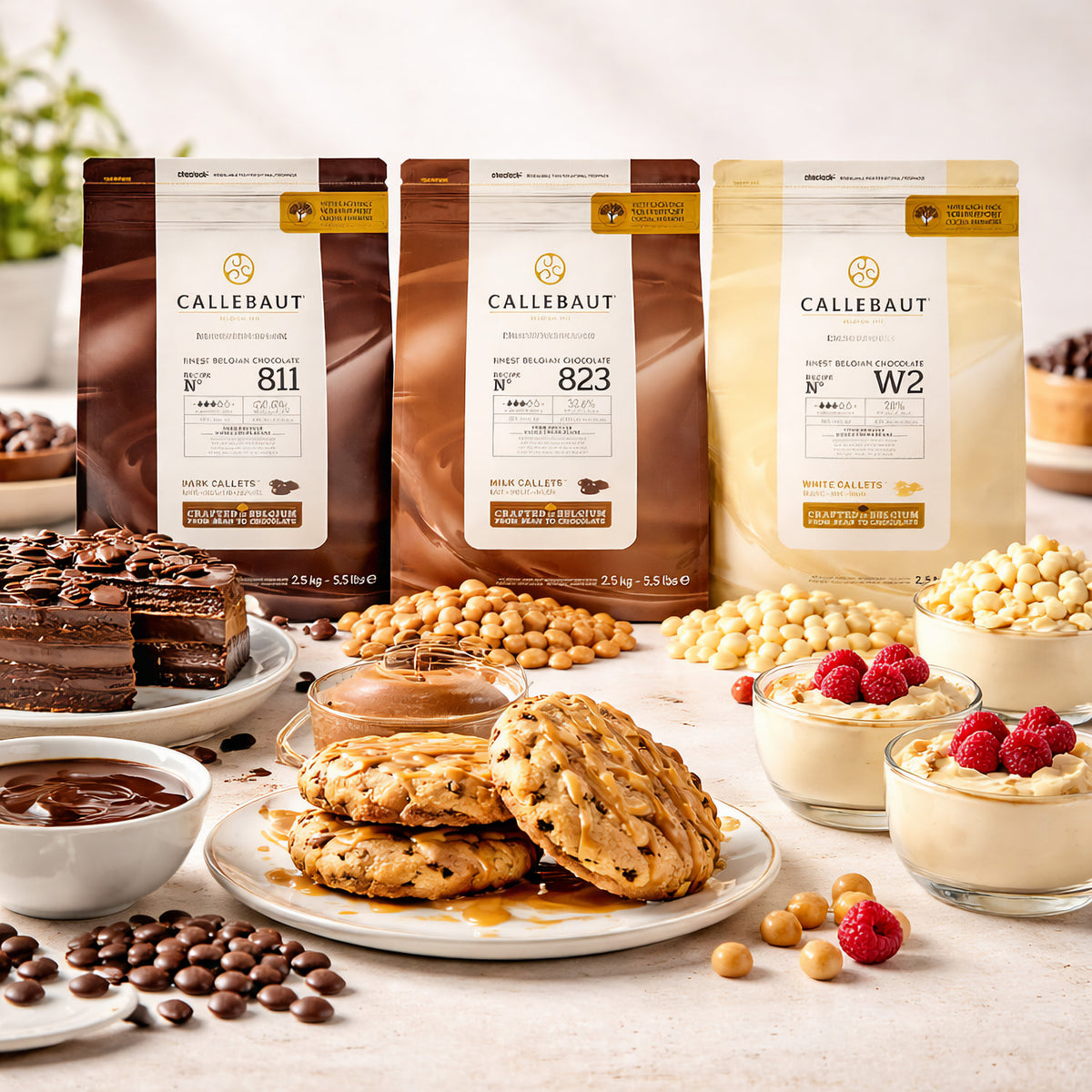 Callebaut Kuvertüre 3x2500g in den Sorten Zartbitter-, Milch- und weiße Schokolade, umgeben von Cookies, Kuchen, Schokoladensoße und Dessert mit Himbeeren, ideal zum Backen.