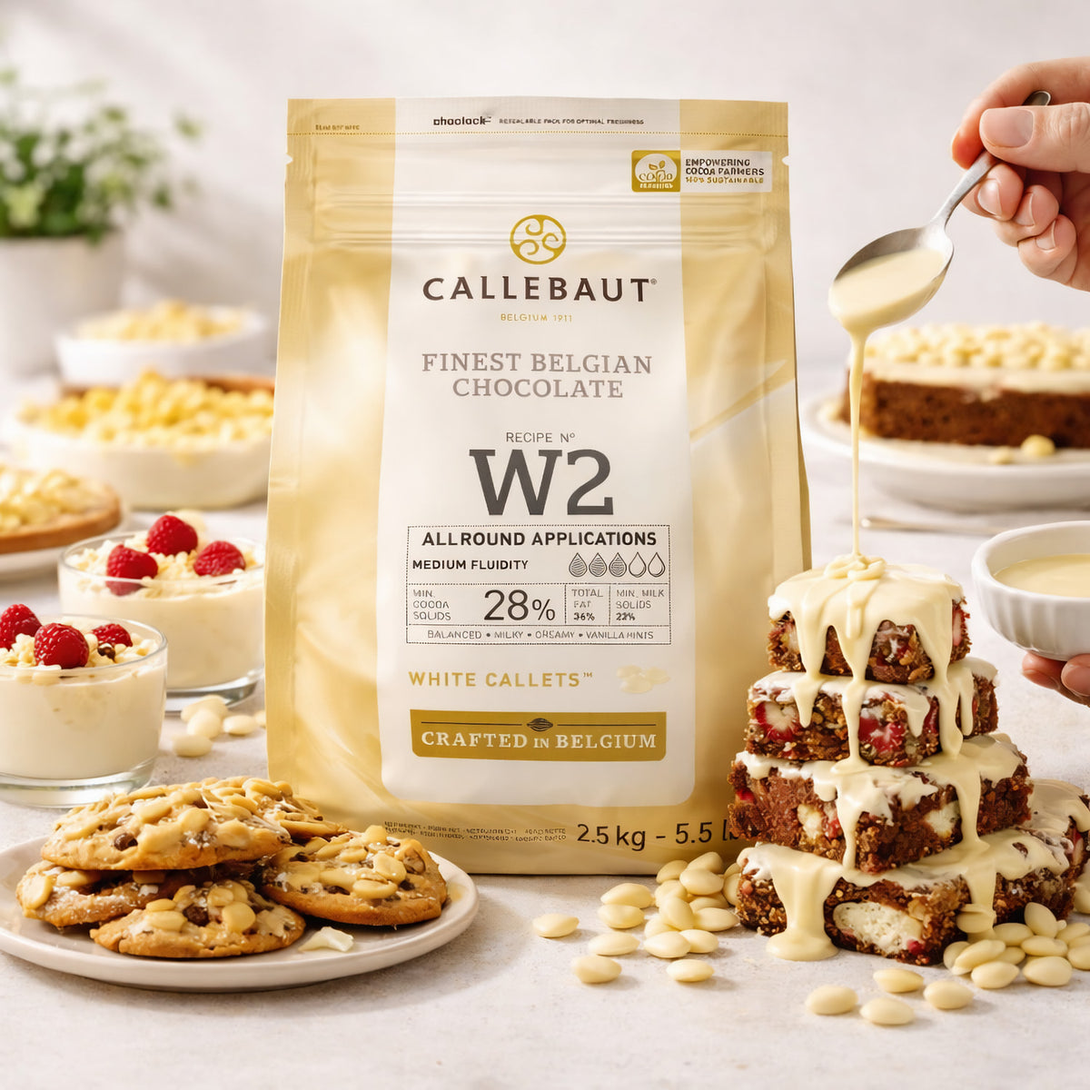 Callebaut Kuvertüre Callets weiße Schokolade beim Backen, mit Cookies, Kuchen und Dessert im Hintergrund, Schokolade wird über Gebäck gegossen.