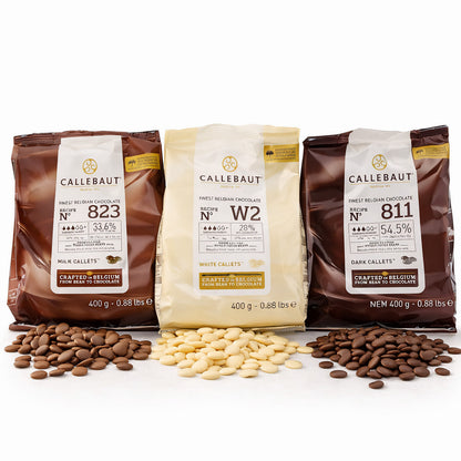 Drei Callebaut Kuvertüre Callets Packungen à 400g in den Sorten Zartbitter-, Milch- und weiße Schokolade, jeweils mit passenden Schoko-Callets davor auf weißem Untergrund.